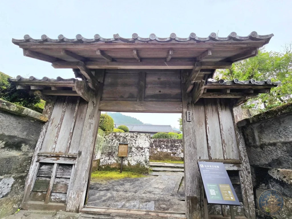 Traditional wooden gate entrance to Sata Shigetada Garden (Garden 6), one of the beautiful dry landscape gardens in the historic Chiran Samurai District. Classic samurai residence architecture in Kagoshima, Japan. Kagoshima Cruise Port Guide | Things to do in Kagoshima from cruise ship | One day in Kagoshima Japan itinerary by Danny and Peter.