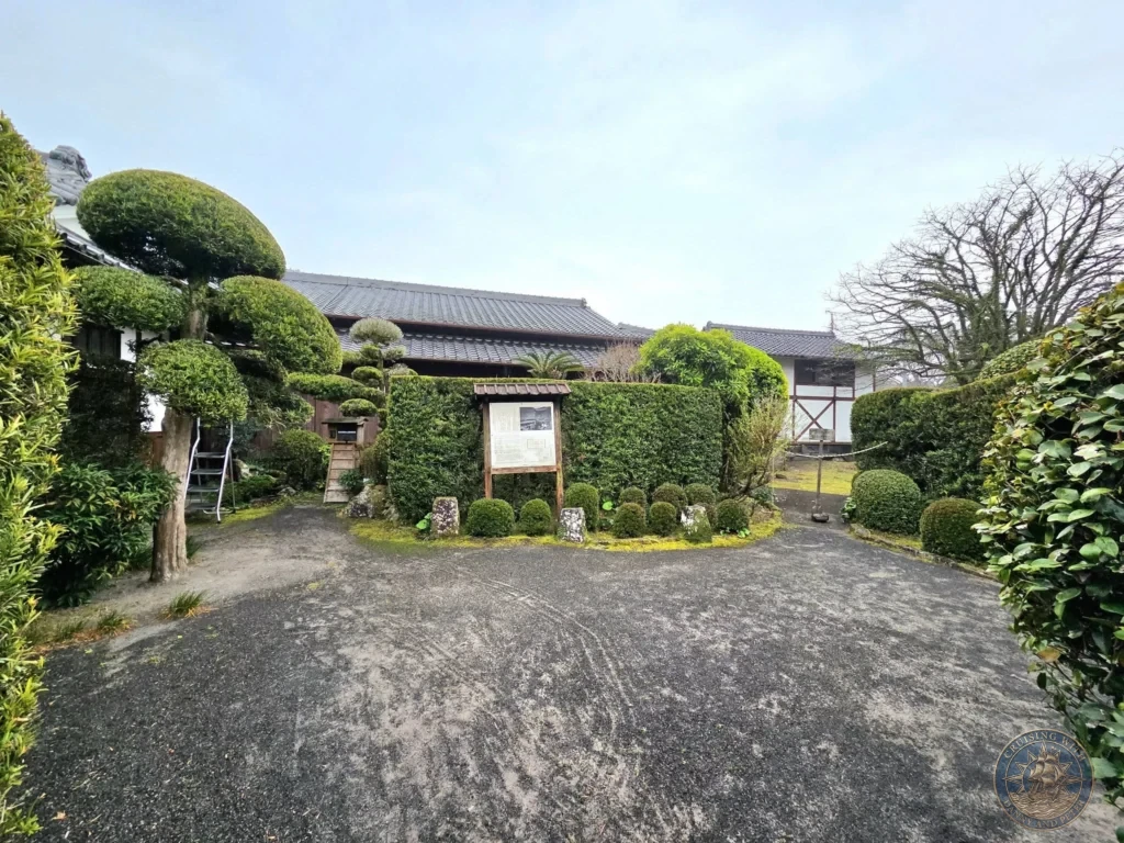 Peaceful courtyard view inside Sata Shigetada Garden (Garden 6), one of the seven historic dry landscape samurai gardens in Chiran Samurai District. Beautiful cloud-pruned trees, manicured hedges, and traditional buildings in Kagoshima, Japan. Kagoshima Cruise Port Guide | Things to do in Kagoshima from cruise ship | One day in Kagoshima Japan itinerary by Danny and Peter.