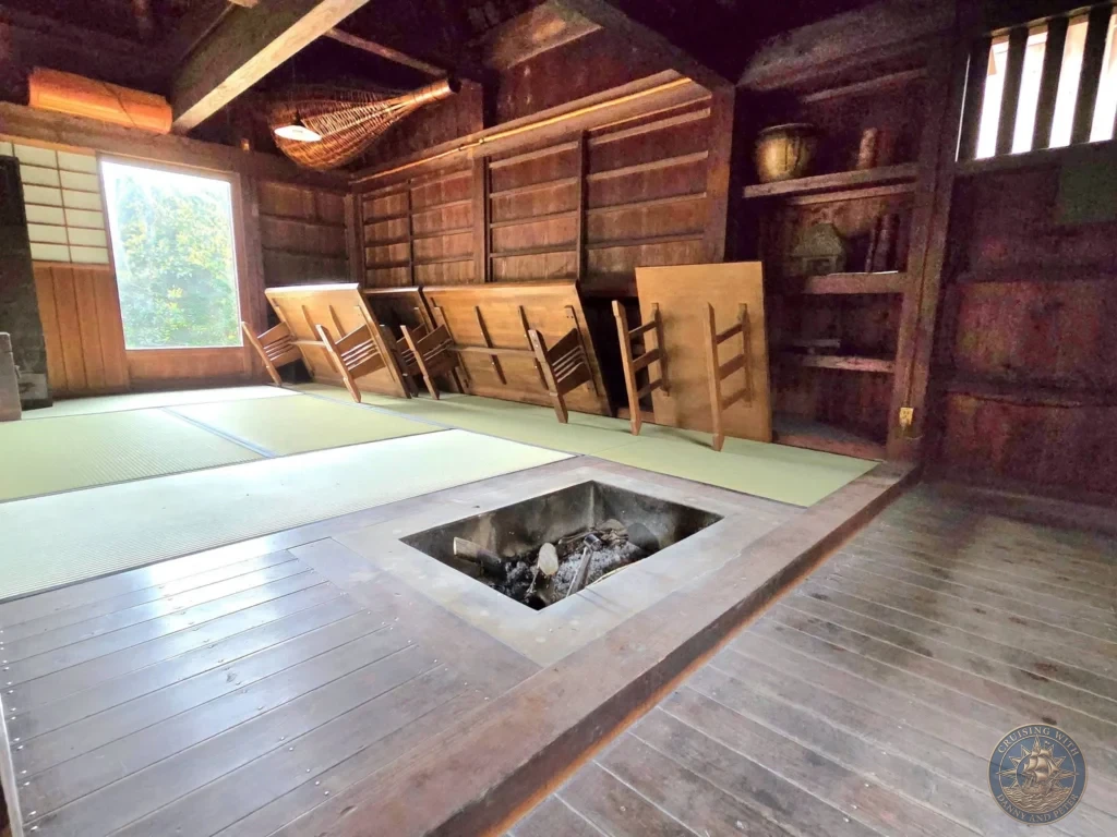 Traditional Japanese irori sunken hearth in the wooden interior of the Futatsuya Samurai House, featuring tatami mats and classic dark wood architecture in the historic Chiran Samurai District. Authentic Edo-period samurai home in Kagoshima, Japan. Kagoshima Cruise Port Guide | Things to do in Kagoshima from cruise ship | One day in Kagoshima Japan itinerary by Danny and Peter.