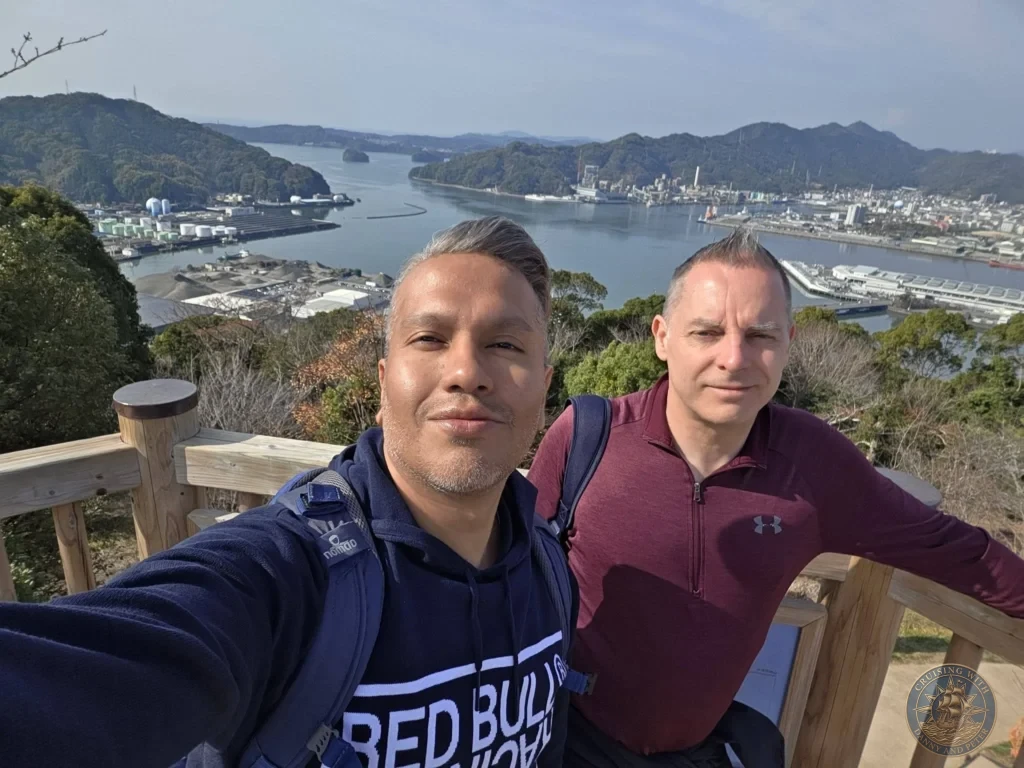 Danny and Peter taking a selfie at Godaisan Observatory overlooking Kochi harbor, city, and mountains in Kochi, Japan. Scenic panoramic viewpoint. Kochi Cruise Port Guide | Things to do in Kochi from cruise ship | One day in Kochi Japan itinerary by Danny and Peter.