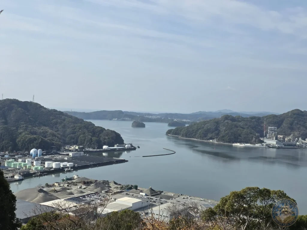 Panoramic view of Kochi harbor, port facilities, and surrounding mountains from Godaisan Observatory in Kochi, Japan. Scenic overlook of the bay and city. Kochi Cruise Port Guide | Things to do in Kochi from cruise ship | One day in Kochi Japan itinerary by Danny and Peter.