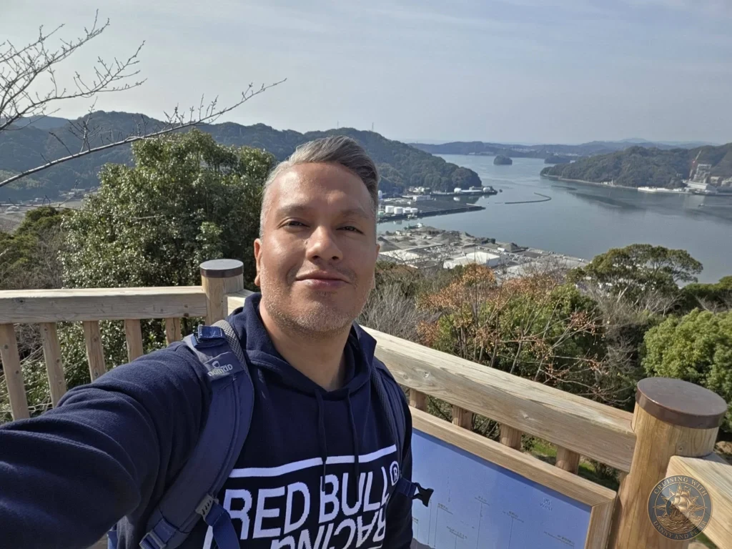 Danny taking a selfie at Godaisan Observatory overlooking Kochi harbor and mountains in Kochi, Japan. Scenic panoramic viewpoint. Kochi Cruise Port Guide | Things to do in Kochi from cruise ship | One day in Kochi Japan itinerary by Danny and Peter.