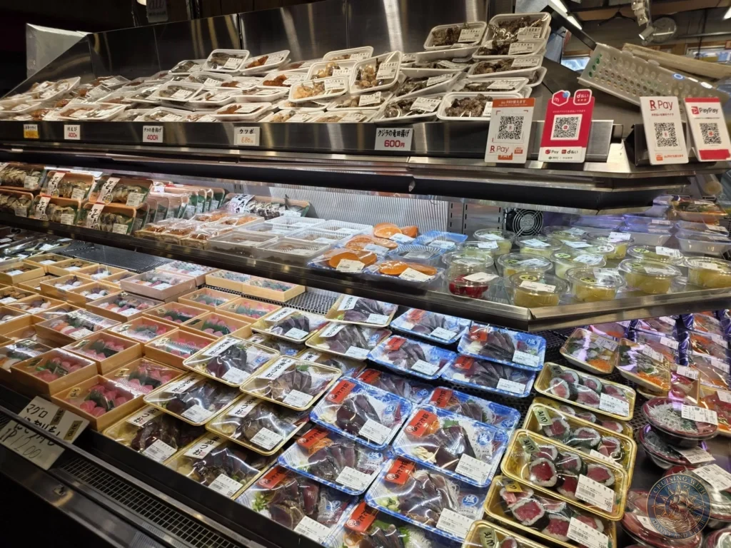 Variety of fresh seafood dishes and ready-to-eat items on display at Hirome Market in Kochi, Japan. Bustling local food market with popular specialties. Kochi Cruise Port Guide | Things to do in Kochi from cruise ship | One day in Kochi Japan itinerary by Danny and Peter.