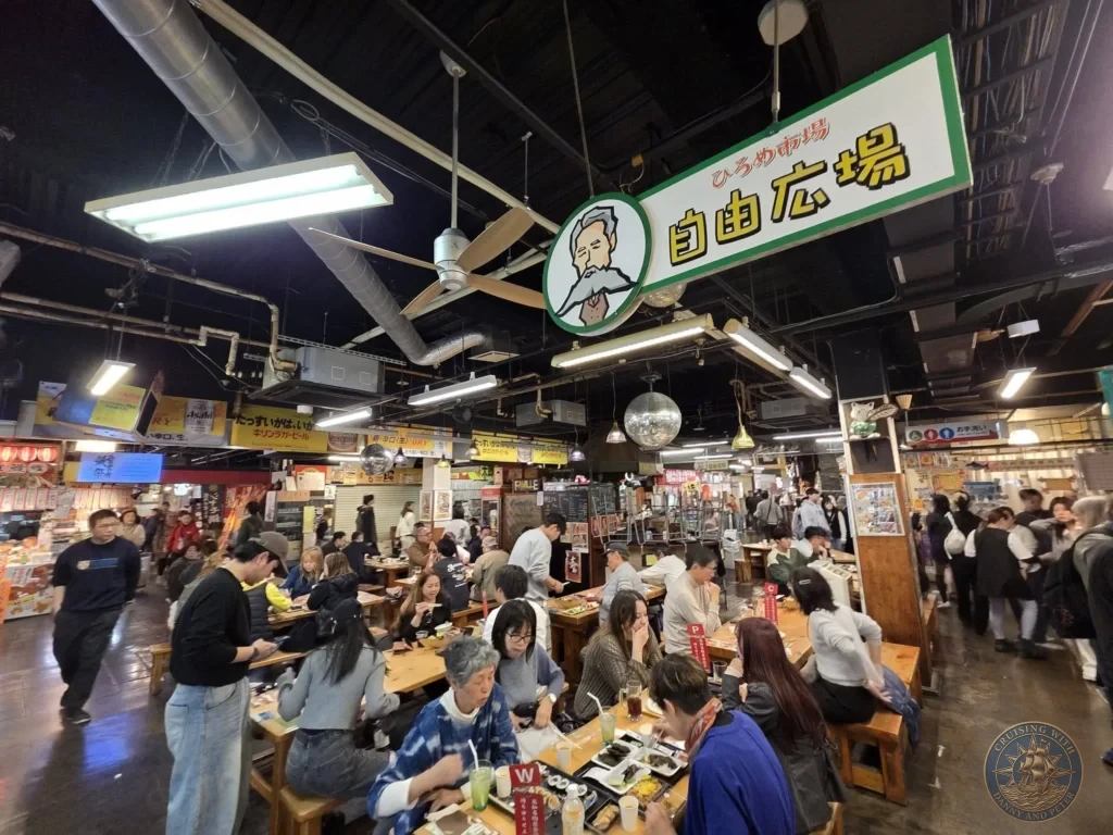 Lively food court at Hirome Market in Kochi, Japan. Crowded with diners enjoying local specialties in the bustling covered market hall. Kochi Cruise Port Guide | Things to do in Kochi from cruise ship | One day in Kochi Japan itinerary by Danny and Peter.