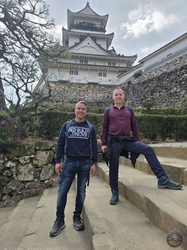 Danny and Peter standing in front of the iconic Kochi Castle keep in Kochi, Japan. Historic white castle with stone walls and traditional architecture. Kochi Cruise Port Guide | Things to do in Kochi from cruise ship | One day in Kochi Japan itinerary by Danny and Peter.