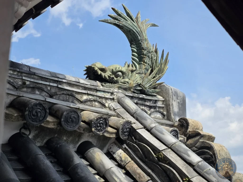 Detailed bronze shachihoko mythical creature roof ornament on Kochi Castle in Kochi, Japan. Traditional decorative element on historic castle roof. Kochi Cruise Port Guide | Things to do in Kochi from cruise ship | One day in Kochi Japan itinerary by Danny and Peter.