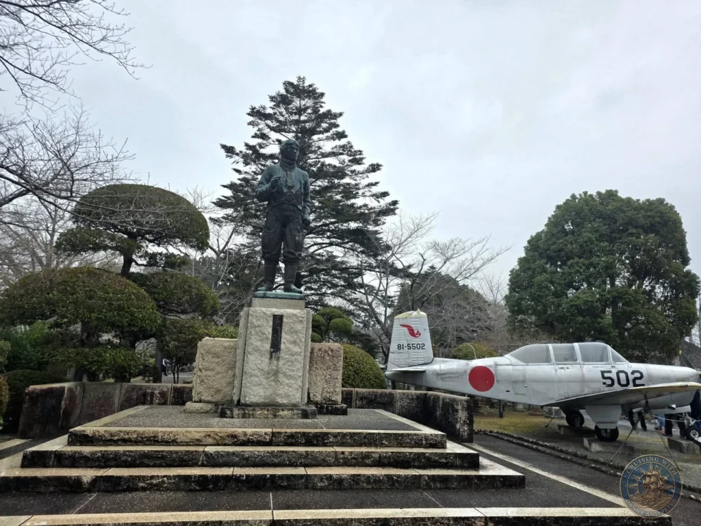 Bronze statue of a Kamikaze pilot overlooking a preserved aircraft at the Chiran Peace Museum. Powerful memorial dedicated to the Special Attack Forces in the Chiran Samurai District, Kagoshima, Japan. Kagoshima Cruise Port Guide | Things to do in Kagoshima from cruise ship | One day in Kagoshima Japan itinerary by Danny and Peter.