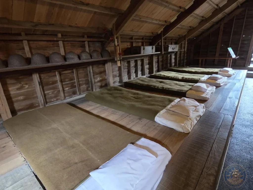 Reconstructed sleeping quarters with simple futon beds and pilot helmets lined up at the Chiran Peace Museum for Kamikaze Pilots. Authentic recreation of the barracks where young Special Attack Force pilots stayed in Chiran, Kagoshima, Japan. Kagoshima Cruise Port Guide | Things to do in Kagoshima from cruise ship | One day in Kagoshima Japan itinerary by Danny and Peter.