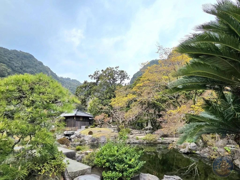 Serene pond garden with traditional wooden pavilion, sculpted pines, and lush greenery at Sengan-en (Iso Garden), the historic UNESCO World Heritage samurai villa overlooking Sakurajima in Kagoshima, Japan. Kagoshima Cruise Port Guide | Things to do in Kagoshima from cruise ship | One day in Kagoshima Japan itinerary by Danny and Peter.