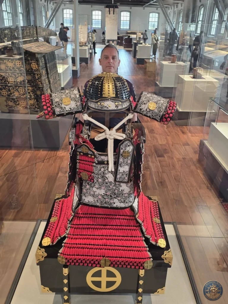 Peter posing with a magnificent traditional samurai armor display at the Shoko Shuseikan UNESCO World Cultural Heritage Museum in Sengan-en, Kagoshima, Japan. Historic Shimazu clan artifacts inside the museum. Kagoshima Cruise Port Guide | Things to do in Kagoshima from cruise ship | One day in Kagoshima Japan itinerary by Danny and Peter.