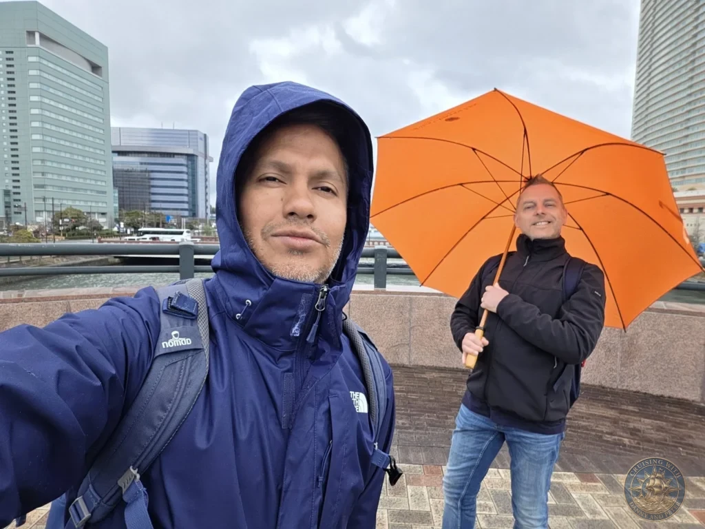 Danny and Peter taking a selfie in Fukuoka city with modern buildings in the background, Japan. Cruise port exploration. Fukuoka Cruise Port Guide | Things to do in Fukuoka from cruise ship | One day in Fukuoka Japan itinerary by Danny and Peter.