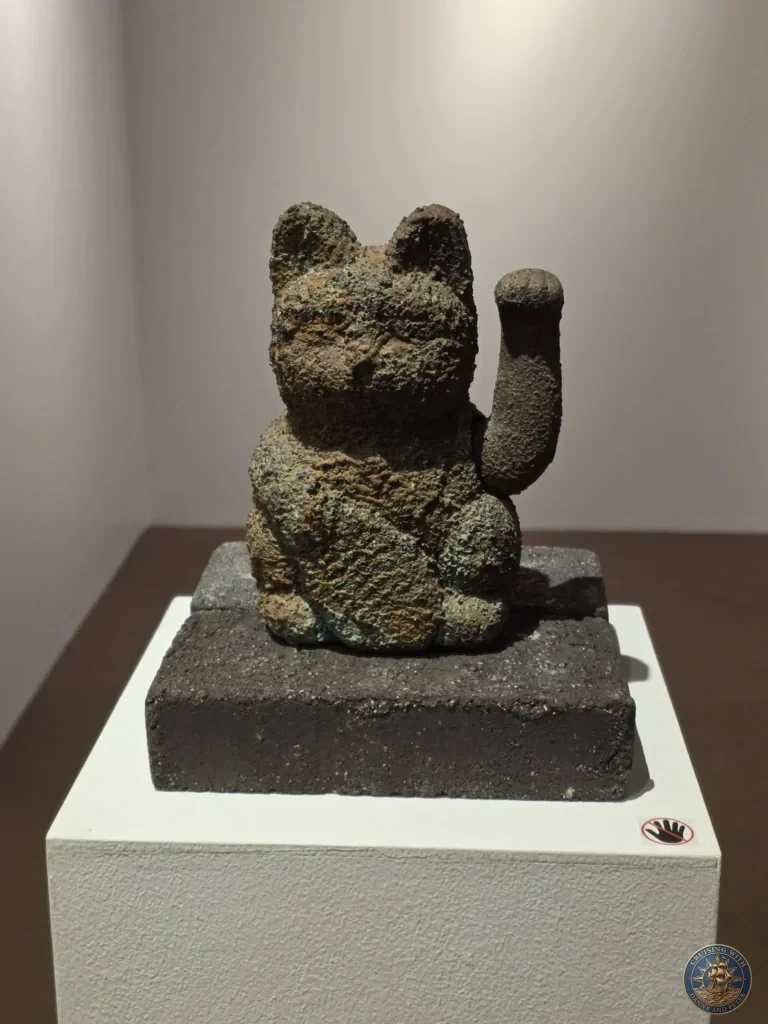 Maneki-neko beckoning cat statue exhibited at Fukuoka City Museum in Japan. Traditional artifact. Fukuoka Cruise Port Guide | Things to do in Fukuoka from cruise ship | One day in Fukuoka Japan itinerary by Danny and Peter.