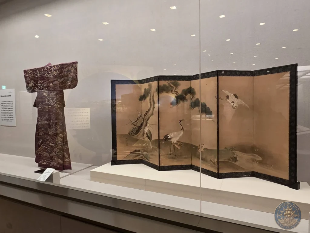 Traditional purple kimono and folding screen with crane artwork displayed at Fukuoka City Museum in Japan. Classic Japanese art. Fukuoka Cruise Port Guide | Things to do in Fukuoka from cruise ship | One day in Fukuoka Japan itinerary by Danny and Peter.