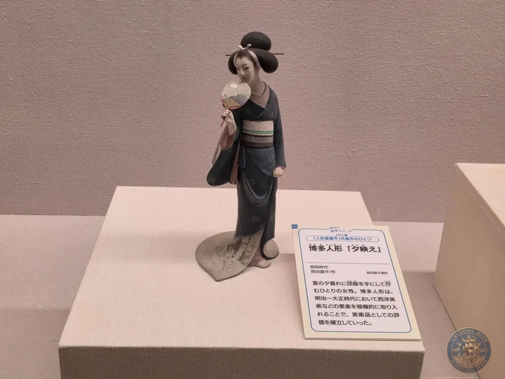 Graceful ningyo doll in traditional kimono holding a fan at Fukuoka City Museum, Japan. Cultural exhibit. Fukuoka Cruise Port Guide | Things to do in Fukuoka from cruise ship | One day in Fukuoka Japan itinerary by Danny and Peter.