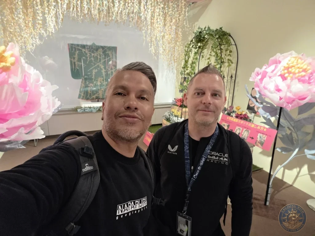 Danny and Peter taking a selfie in the vibrant floral and golden hanging installation at Fukuoka City Museum, Japan. Interactive exhibit. Fukuoka Cruise Port Guide | Things to do in Fukuoka from cruise ship | One day in Fukuoka Japan itinerary by Danny and Peter.