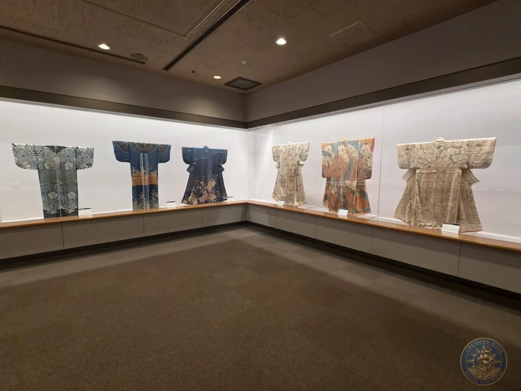 Row of elegant traditional Japanese kimonos in glass cases at Fukuoka City Museum, Japan. Historic textile exhibit. Fukuoka Cruise Port Guide | Things to do in Fukuoka from cruise ship | One day in Fukuoka Japan itinerary by Danny and Peter.