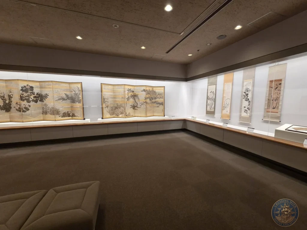 Spacious gallery with traditional Japanese folding screens and hanging scrolls at Fukuoka City Museum, Japan. Historic art display. Fukuoka Cruise Port Guide | Things to do in Fukuoka from cruise ship | One day in Fukuoka Japan itinerary by Danny and Peter.