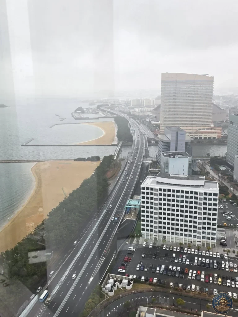Foggy panoramic view of Fukuoka coastline, sandy beach, highway and city buildings from Fukuoka Tower, Japan. Landmark overlook. Fukuoka Cruise Port Guide | Things to do in Fukuoka from cruise ship | One day in Fukuoka Japan itinerary by Danny and Peter.
