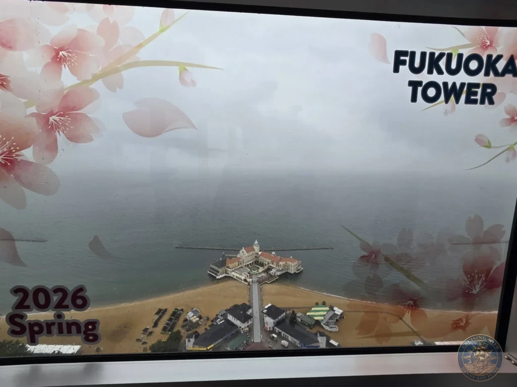 Panoramic coastal view from Fukuoka Tower with cherry blossom window decorations overlooking beach and sea in Fukuoka, Japan. Landmark observation. Fukuoka Cruise Port Guide | Things to do in Fukuoka from cruise ship | One day in Fukuoka Japan itinerary by Danny and Peter.