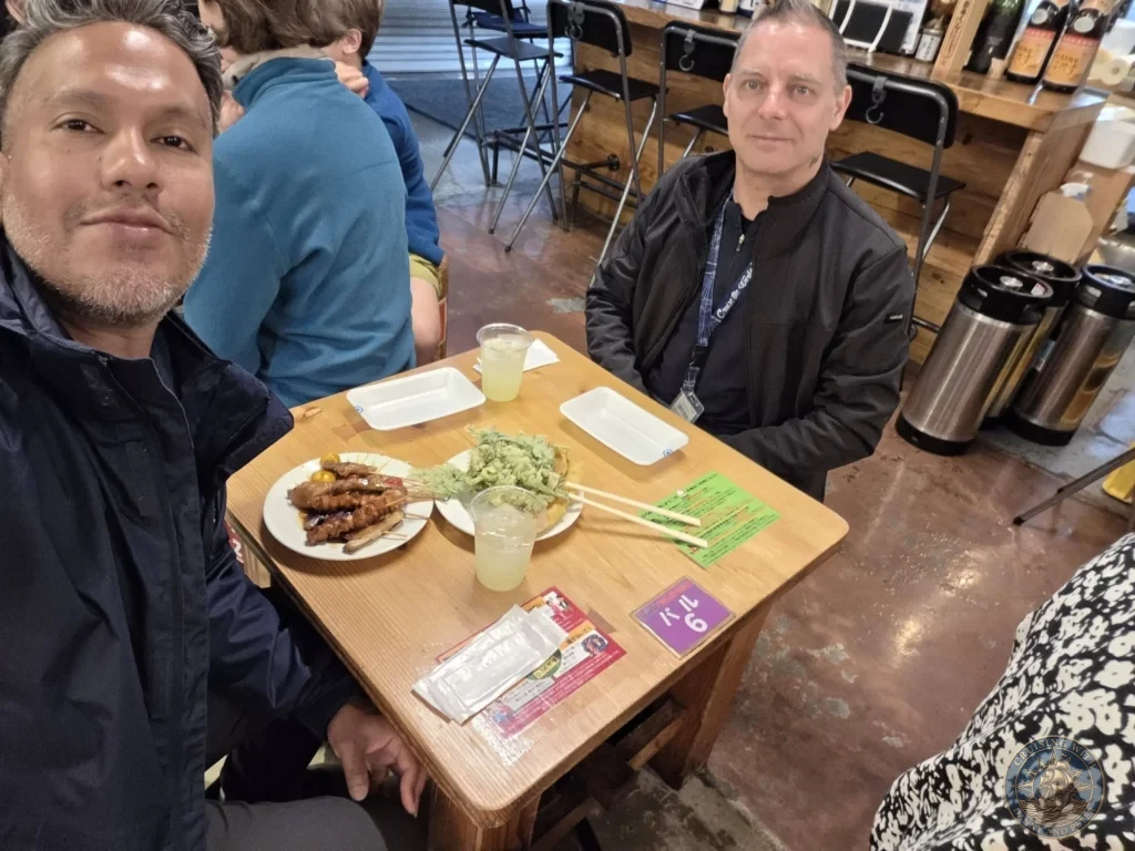 Danny and Peter taking a selfie while dining at Hirome Market in Kochi, Japan. Busy food court with plates of local specialties. Kochi Cruise Port Guide | Things to do in Kochi from cruise ship | One day in Kochi Japan itinerary by Danny and Peter.