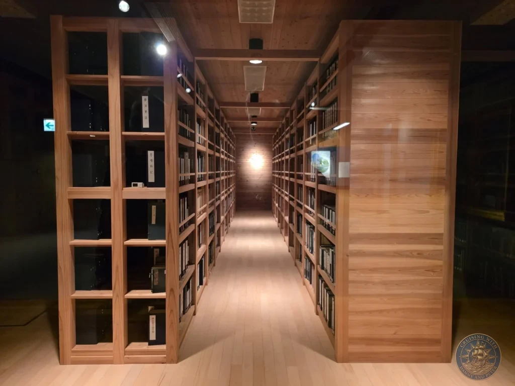 Long hallway of wooden bookshelves in the library at Makino Botanical Garden in Kochi, Japan. Peaceful research space surrounded by natural wood. Kochi Cruise Port Guide | Things to do in Kochi from cruise ship | One day in Kochi Japan itinerary by Danny and Peter.