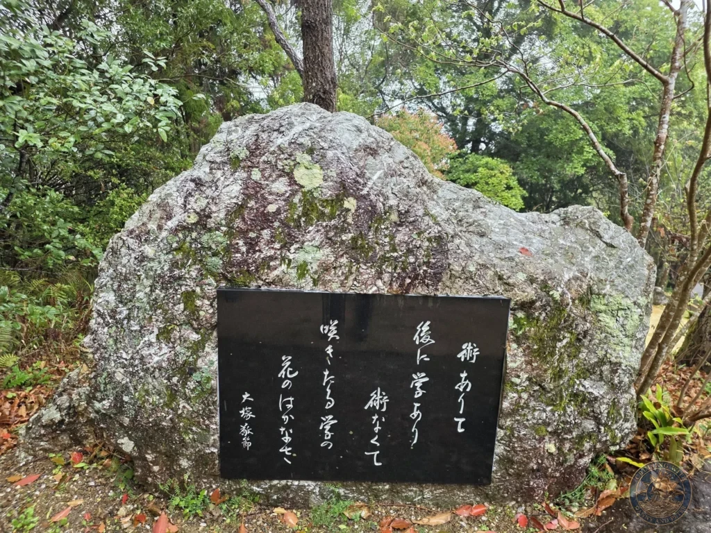 Large natural stone with black calligraphy plaque at Makino Botanical Garden in Kochi, Japan. Inspirational monument in garden setting. Kochi Cruise Port Guide | Things to do in Kochi from cruise ship | One day in Kochi Japan itinerary by Danny and Peter.