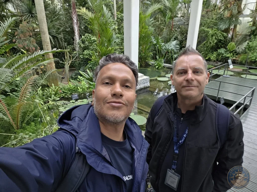 Danny and Peter taking a selfie by the lily pad pond in the lush greenhouse at Makino Botanical Garden in Kochi, Japan. Tropical conservatory scene. Kochi Cruise Port Guide | Things to do in Kochi from cruise ship | One day in Kochi Japan itinerary by Danny and Peter.