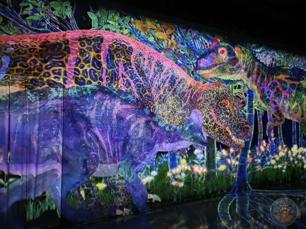 Vivid digital dinosaurs in the glowing immersive forest at teamLab Forest Fukuoka, Japan. Digital art installation. Fukuoka Cruise Port Guide | Things to do in Fukuoka from cruise ship | One day in Fukuoka Japan itinerary by Danny and Peter.