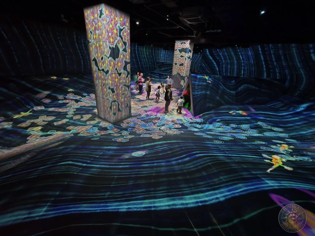 Dynamic glowing wavy floor patterns and colorful light towers in the immersive teamLab Forest Fukuoka, Japan. Digital art experience. Fukuoka Cruise Port Guide | Things to do in Fukuoka from cruise ship | One day in Fukuoka Japan itinerary by Danny and Peter.