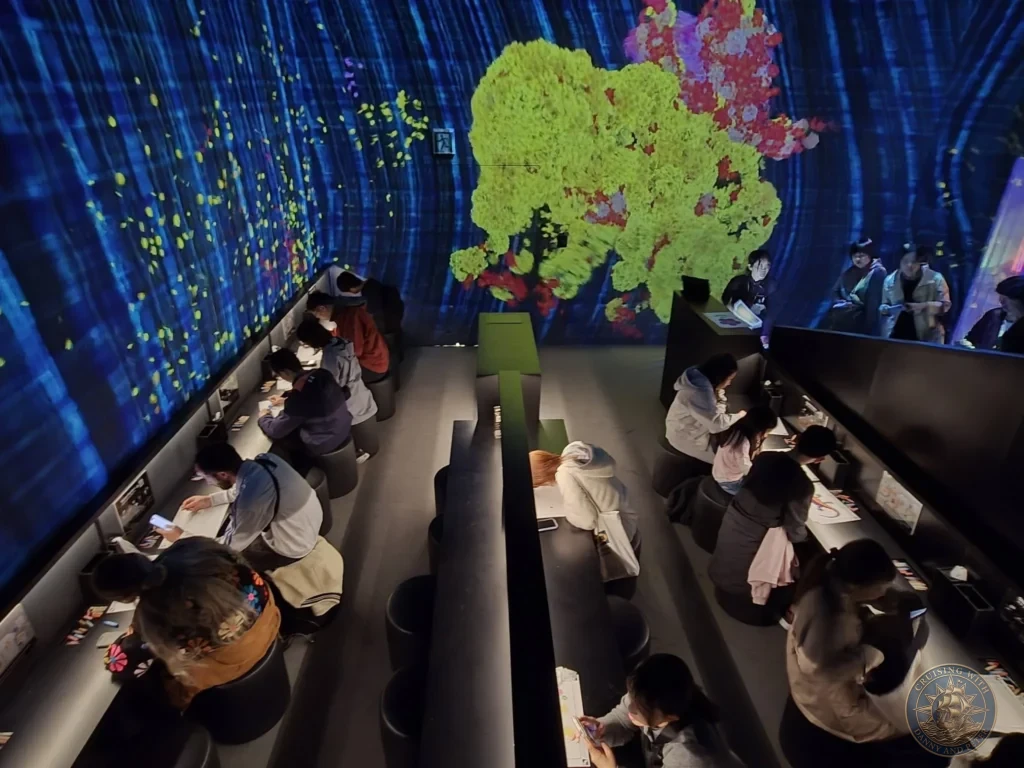 Visitors drawing at illuminated tables in the glowing interactive room at teamLab Forest Fukuoka, Japan. Creative digital art experience. Fukuoka Cruise Port Guide | Things to do in Fukuoka from cruise ship | One day in Fukuoka Japan itinerary by Danny and Peter.