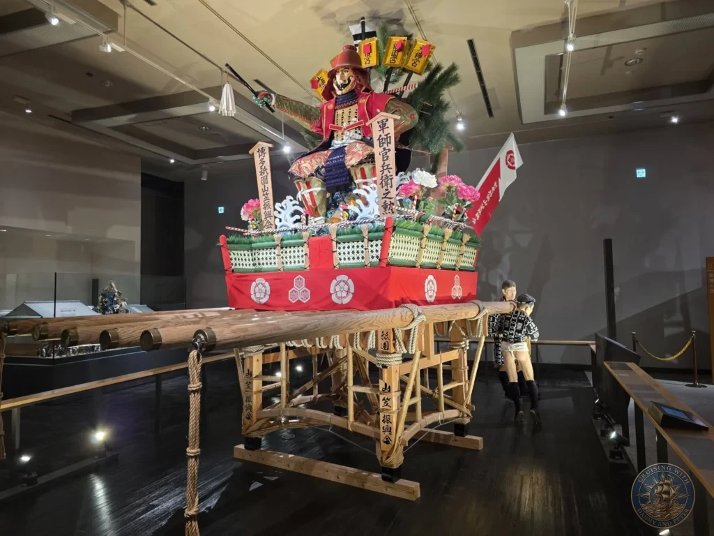Detailed Yamakasa festival float with prominent warrior figure at Fukuoka City Museum, Japan. Festival heritage display. Fukuoka Cruise Port Guide | Things to do in Fukuoka from cruise ship | One day in Fukuoka Japan itinerary by Danny and Peter.
