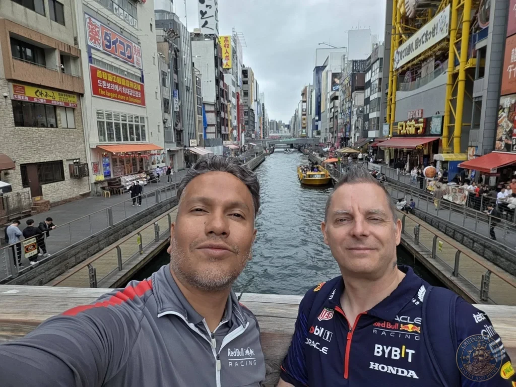 Kobe Japan Cruise Port Guide 2026 – Insider Tips & One Day Itinerary 151 Danny and Peter taking a selfie on a bridge overlooking the Dotonbori canal lined with shops and restaurants in Osaka, Japan. Classic canal view from Kobe port day. Kobe Japan Cruise Port Guide | DIY Kobe Cruise Port to City Center | Things to do in Kobe from cruise ship | Westerdam Kobe Docking Location | One day in Kobe Japan itinerary by Danny and Peter.