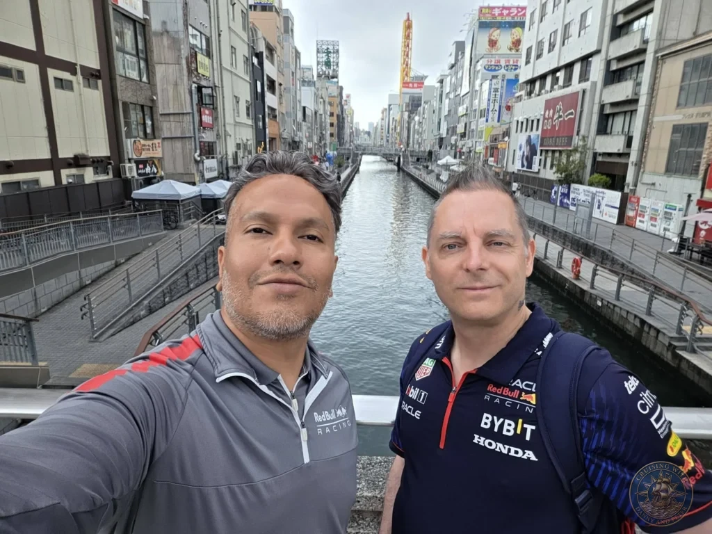 Kobe Japan Cruise Port Guide 2026 – Insider Tips & One Day Itinerary 157 Danny and Peter taking a selfie on a bridge above the Dotonbori canal with shops and buildings lining both sides in Osaka, Japan. Canal view from Kobe port day. Kobe Japan Cruise Port Guide | DIY Kobe Cruise Port to City Center | Things to do in Kobe from cruise ship | Westerdam Kobe Docking Location | One day in Kobe Japan itinerary by Danny and Peter.