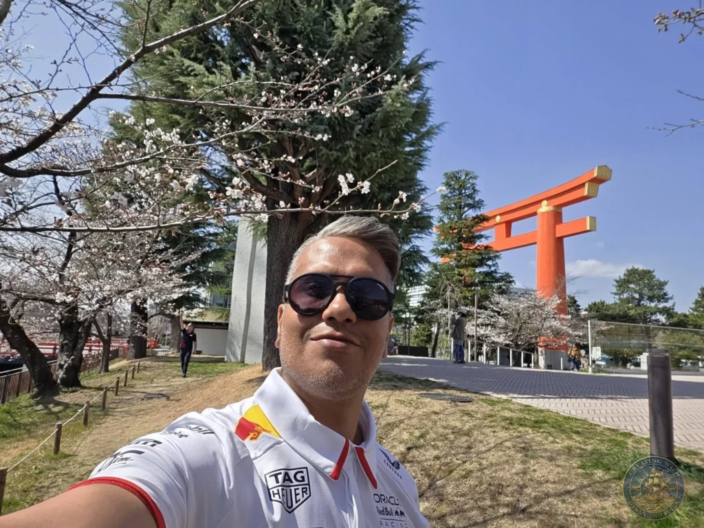 Kobe Japan Cruise Port Guide 2026 – Insider Tips & One Day Itinerary 21 Danny taking a selfie in front of the large orange torii gate of Heian Shrine with cherry blossoms in Kyoto, Japan. Spring visit from Kobe. Kobe Japan Cruise Port Guide | DIY Kobe Cruise Port to City Center | Things to do in Kobe from cruise ship | Westerdam Kobe Docking Location | One day in Kobe Japan itinerary by Danny and Peter.
