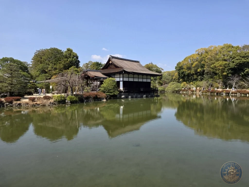 Kobe Japan Cruise Port Guide 2026 – Insider Tips & One Day Itinerary 63 Traditional Japanese pavilion reflecting in a calm pond surrounded by trees at Heian Shrine under a clear blue sky in Kyoto, Japan. Shrine gardens from Kobe port day. Kobe Japan Cruise Port Guide | DIY Kobe Cruise Port to City Center | Things to do in Kobe from cruise ship | Westerdam Kobe Docking Location | One day in Kobe Japan itinerary by Danny and Peter.