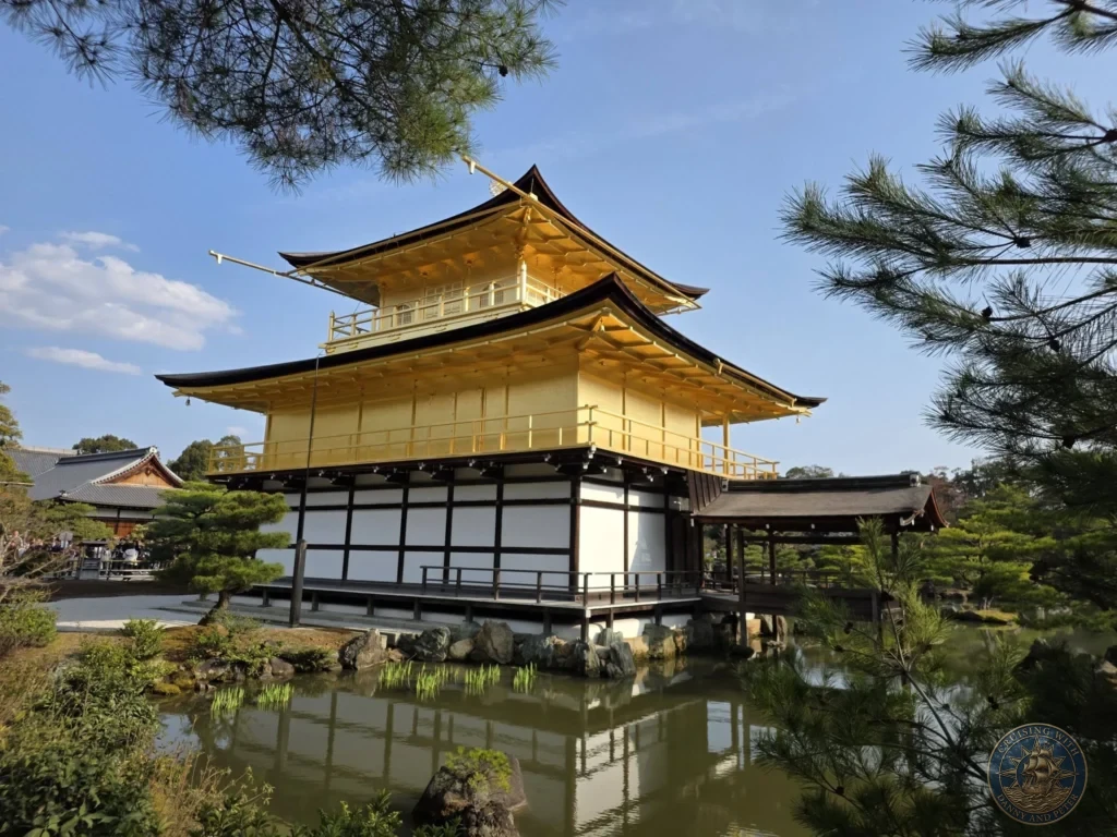 Kobe Japan Cruise Port Guide 2026 – Insider Tips & One Day Itinerary 22 Side view of the Golden Pavilion (Kinkaku-ji) with its reflection in the pond, pine trees, and blue sky in Kyoto, Japan. Temple scene from Kobe. Kobe Japan Cruise Port Guide | DIY Kobe Cruise Port to City Center | Things to do in Kobe from cruise ship | Westerdam Kobe Docking Location | One day in Kobe Japan itinerary by Danny and Peter.