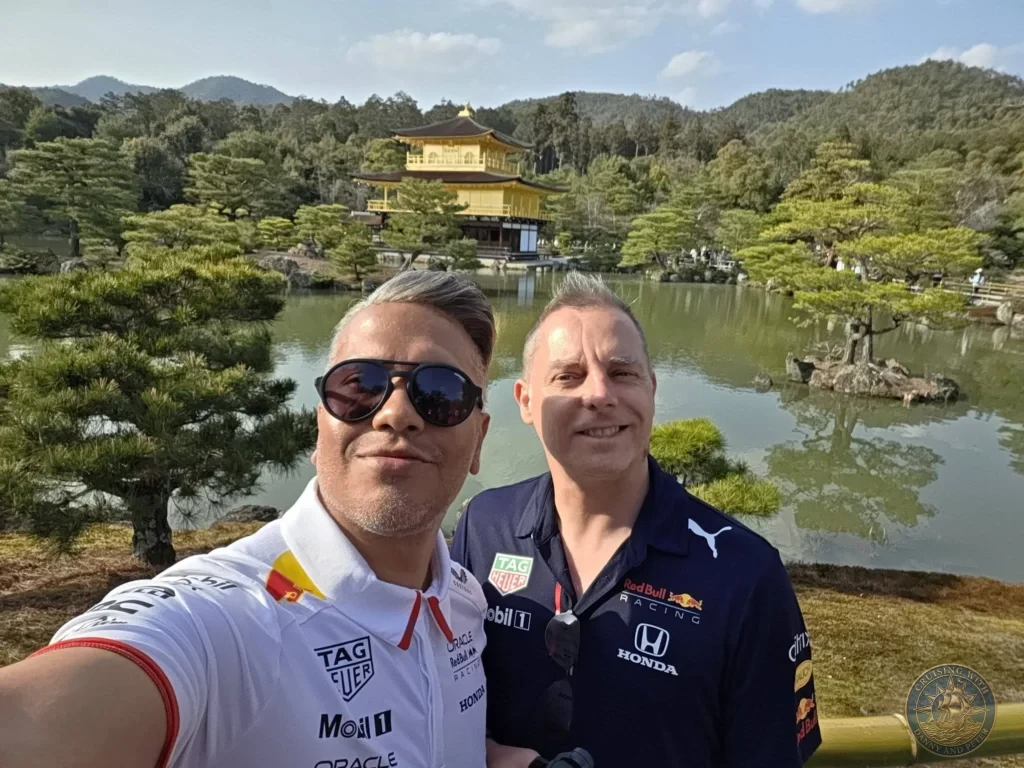 Kobe Japan Cruise Port Guide 2026 – Insider Tips & One Day Itinerary 31 Danny and Peter taking a selfie with the Golden Pavilion (Kinkaku-ji) and its pond reflection in the background in Kyoto, Japan. Temple visit from Kobe. Kobe Japan Cruise Port Guide | DIY Kobe Cruise Port to City Center | Things to do in Kobe from cruise ship | Westerdam Kobe Docking Location | One day in Kobe Japan itinerary by Danny and Peter.