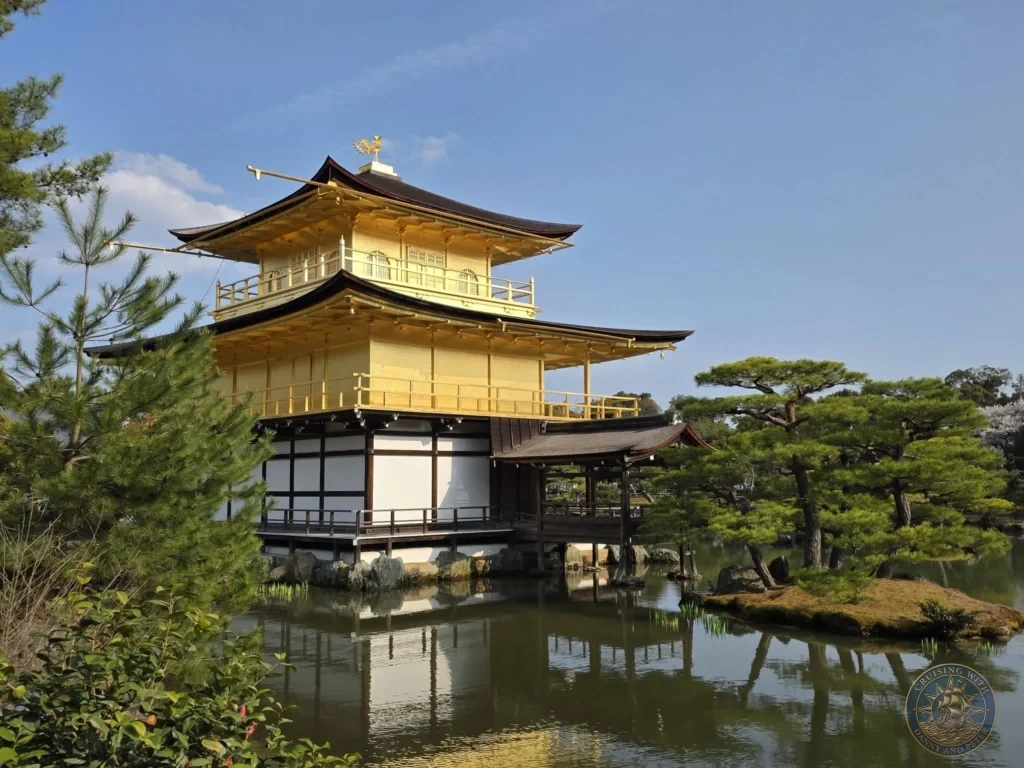 Kobe Japan Cruise Port Guide 2026 – Insider Tips & One Day Itinerary 70 Golden Pavilion (Kinkaku-ji) reflecting in the pond with pine trees under a clear blue sky in Kyoto, Japan. Iconic temple from Kobe port day. Kobe Japan Cruise Port Guide | DIY Kobe Cruise Port to City Center | Things to do in Kobe from cruise ship | Westerdam Kobe Docking Location | One day in Kobe Japan itinerary by Danny and Peter.