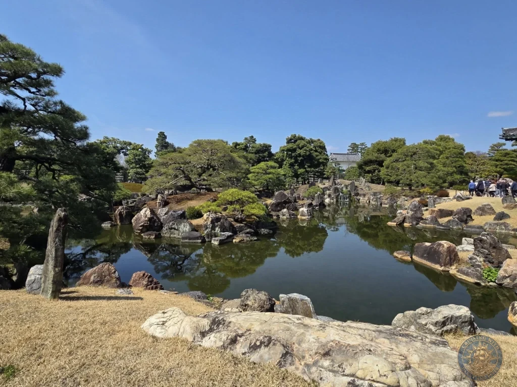 Kobe Japan Cruise Port Guide 2026 – Insider Tips & One Day Itinerary 32 Traditional Japanese garden with pond, rocks, and pine trees at Nijo Castle under a clear blue sky in Kyoto, Japan. Historic gardens from Kobe port day. Kobe Japan Cruise Port Guide | DIY Kobe Cruise Port to City Center | Things to do in Kobe from cruise ship | Westerdam Kobe Docking Location | One day in Kobe Japan itinerary by Danny and Peter.