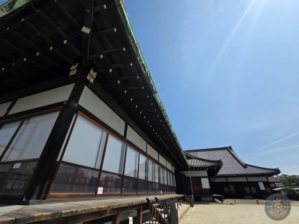 Kobe Japan Cruise Port Guide 2026 – Insider Tips & One Day Itinerary 72 Traditional wooden buildings and tiled roofs of Nijo Castle under a clear blue sky in Kyoto, Japan. Historic palace architecture from Kobe port day. Kobe Japan Cruise Port Guide | DIY Kobe Cruise Port to City Center | Things to do in Kobe from cruise ship | Westerdam Kobe Docking Location | One day in Kobe Japan itinerary by Danny and Peter.