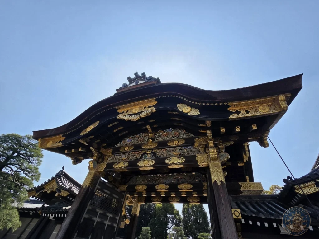 Kobe Japan Cruise Port Guide 2026 – Insider Tips & One Day Itinerary 15 Low-angle view of the highly detailed ornate gate with gold carvings at Nijo Castle under a blue sky in Kyoto, Japan. Historic architecture from Kobe port day. Kobe Japan Cruise Port Guide | DIY Kobe Cruise Port to City Center | Things to do in Kobe from cruise ship | Westerdam Kobe Docking Location | One day in Kobe Japan itinerary by Danny and Peter.