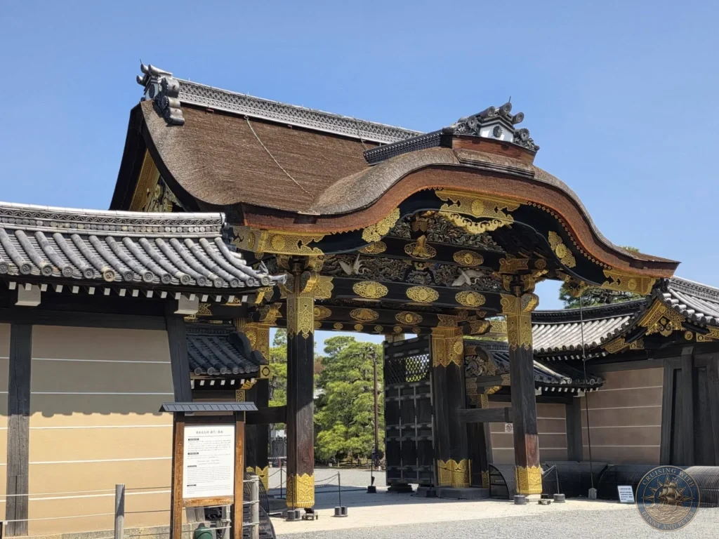 Kobe Japan Cruise Port Guide 2026 – Insider Tips & One Day Itinerary 75 Ornate Kara-mon gate with gold decorations and traditional architecture at Nijo Castle under a clear blue sky in Kyoto, Japan. Historic entrance from Kobe port day. Kobe Japan Cruise Port Guide | DIY Kobe Cruise Port to City Center | Things to do in Kobe from cruise ship | Westerdam Kobe Docking Location | One day in Kobe Japan itinerary by Danny and Peter.
