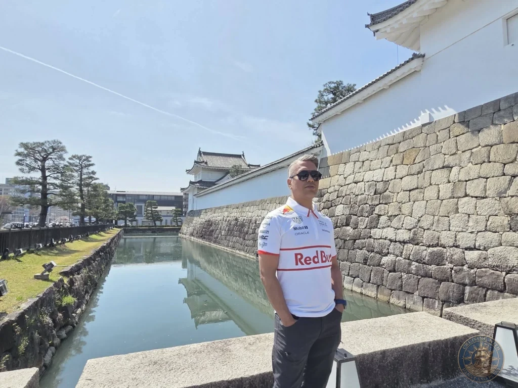 Kobe Japan Cruise Port Guide 2026 – Insider Tips & One Day Itinerary 76 Danny standing by the moat and stone walls of Nijo Castle under a clear blue sky in Kyoto, Japan. Historic castle grounds from Kobe port day. Kobe Japan Cruise Port Guide | DIY Kobe Cruise Port to City Center | Things to do in Kobe from cruise ship | Westerdam Kobe Docking Location | One day in Kobe Japan itinerary by Danny and Peter.