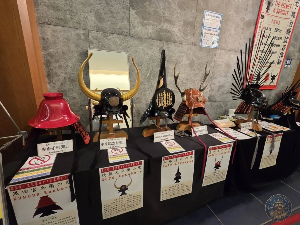 Kobe Japan Cruise Port Guide 2026 – Insider Tips & One Day Itinerary 158 Display of replica samurai helmets including those of Kuroda Kanbe, Goto Matabe, Kato Kiyomasa, Sanada Yukimura and others inside Osaka Castle in Osaka, Japan. Historic exhibit from Kobe port day. Kobe Japan Cruise Port Guide | DIY Kobe Cruise Port to City Center | Things to do in Kobe from cruise ship | Westerdam Kobe Docking Location | One day in Kobe Japan itinerary by Danny and Peter.