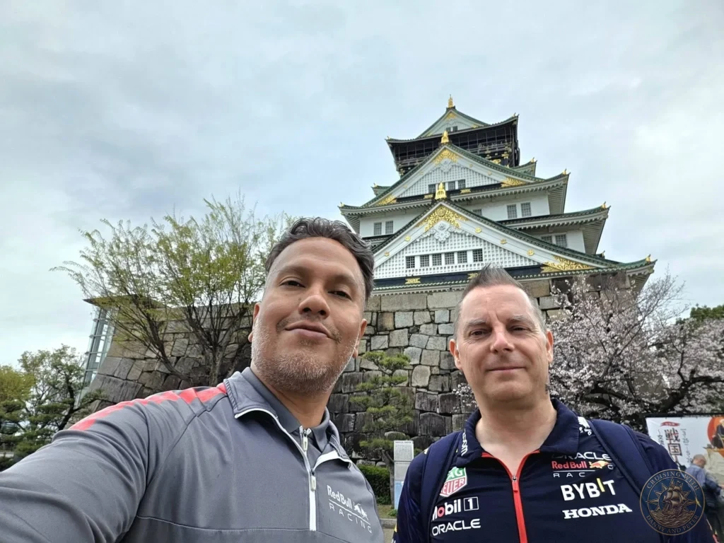 Kobe Japan Cruise Port Guide 2026 – Insider Tips & One Day Itinerary 6 Danny and Peter taking a selfie in front of the main keep of Osaka Castle with its white walls, golden accents and stone base in Osaka, Japan. Iconic landmark from Kobe port day. Kobe Japan Cruise Port Guide | DIY Kobe Cruise Port to City Center | Things to do in Kobe from cruise ship | Westerdam Kobe Docking Location | One day in Kobe Japan itinerary by Danny and Peter.