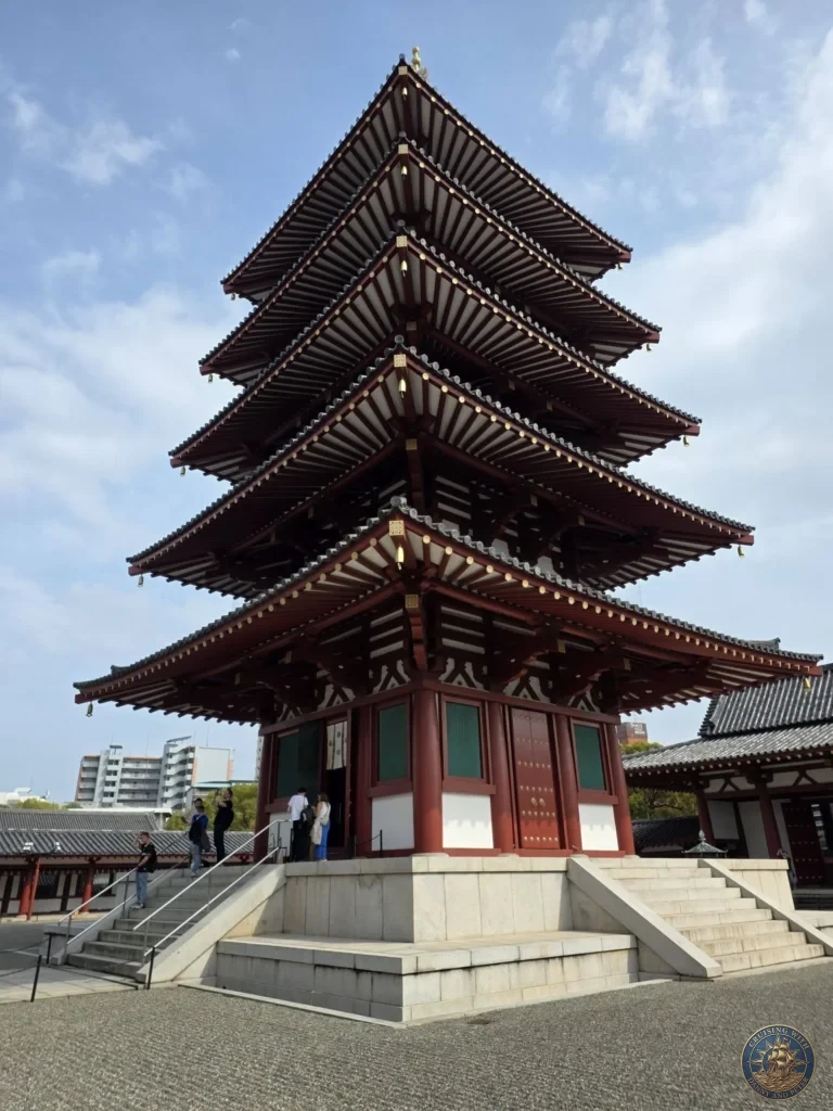 Kobe Japan Cruise Port Guide 2026 – Insider Tips & One Day Itinerary 26 A towering low-angle view of the red wooden five-story pagoda at Shitennoji Temple with its tiered tiled roofs and golden wind bells against a soft blue sky; ideal for a Kobe Japan Cruise Port Guide, DIY Kobe Cruise Port to City Center, Things to do in Kobe from cruise ship, Westerdam Kobe Docking Location, or One day in Kobe Japan itinerary, by Danny and Peter.