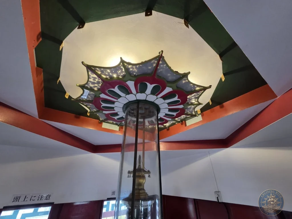 Kobe Japan Cruise Port Guide 2026 – Insider Tips & One Day Itinerary 132 An upward view inside the top floor of the five-story pagoda at Shitennoji Temple, showing a central glass column housing a sacred relic container beneath a colorful lotus-patterned ceiling canopy; ideal for a Kobe Japan Cruise Port Guide, DIY Kobe Cruise Port to City Center, Things to do in Kobe from cruise ship, Westerdam Kobe Docking Location, or One day in Kobe Japan itinerary, by Danny and Peter.