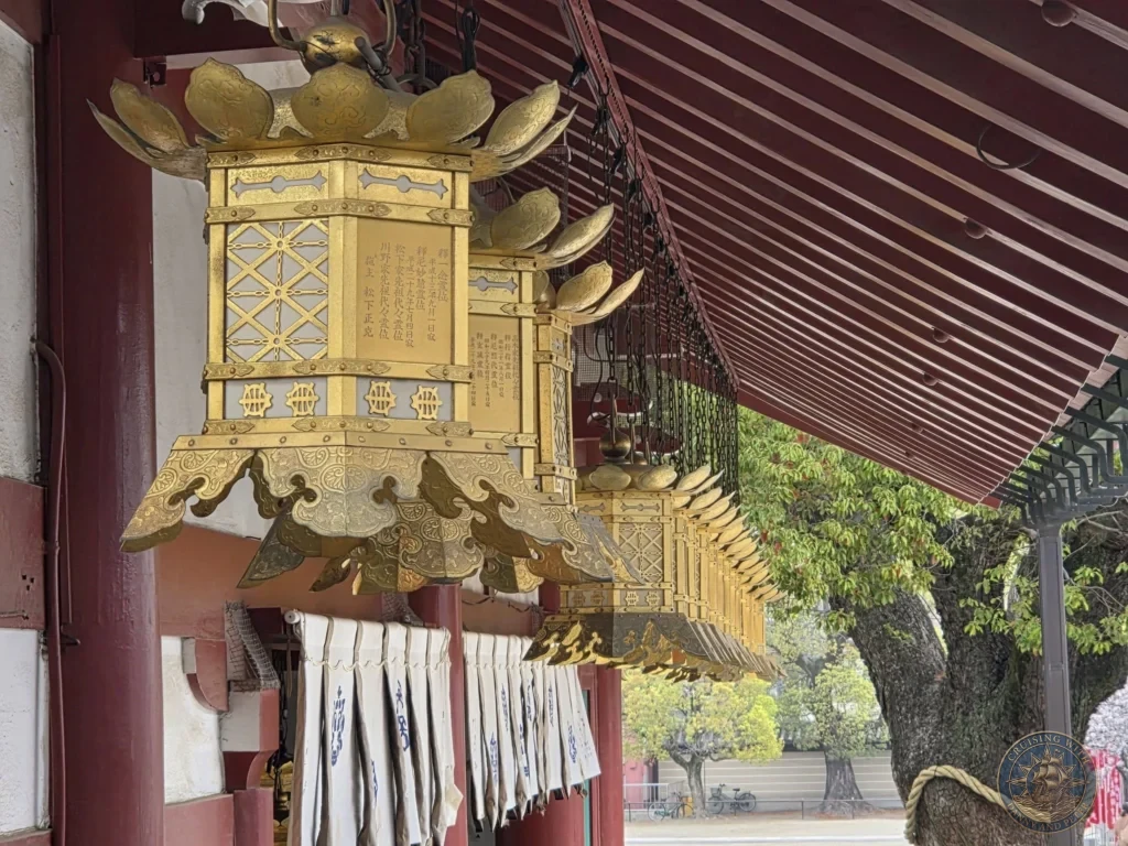 Kobe Japan Cruise Port Guide 2026 – Insider Tips & One Day Itinerary 138 A close-up view of intricate golden brass and bronze hanging lanterns with lotus leaf tops and engraved Japanese inscriptions along the eaves of Kondo Main Hall at Shitennoji Temple in Osaka, Japan; ideal for a Kobe Japan Cruise Port Guide, DIY Kobe Cruise Port to City Center, Things to do in Kobe from cruise ship, MS Westerdam Kobe Docking Location, or One day in Kobe Japan itinerary, by Danny and Peter.