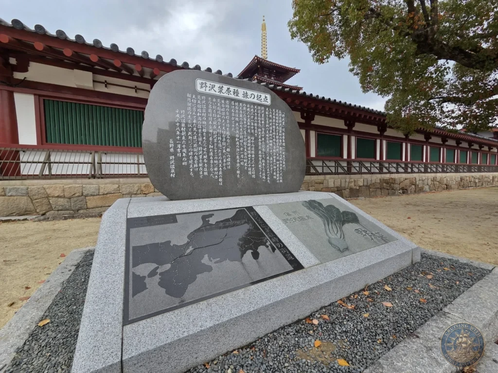 Kobe Japan Cruise Port Guide 2026 – Insider Tips & One Day Itinerary 141 A large engraved granite stone monument with Japanese text, map, and leaf illustrations set in front of the outer corridor wall with the five-story pagoda spire visible in the background at Shitennoji Temple in Osaka, Japan; ideal for a Kobe Japan Cruise Port Guide, DIY Kobe Cruise Port to City Center, Things to do in Kobe from cruise ship, MS Westerdam Kobe Docking Location, or One day in Kobe Japan itinerary, by Danny and Peter.