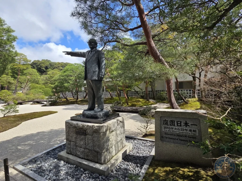 Bronze statue of founder Zenko Adachi pointing toward the gardens with a stone plaque commemorating 22 consecutive years ranked as Japan's top garden at the Adachi Museum of Art during a cruise visit from Sakaiminato Japan Cruise Port Guide, DIY Sakaiminato Cruise Port to City Center, Things to do in Sakaiminato from cruise ship, Westerdam Sakaiminato Docking Location, One day in Sakaiminato Japan itinerary by Danny and Peter.